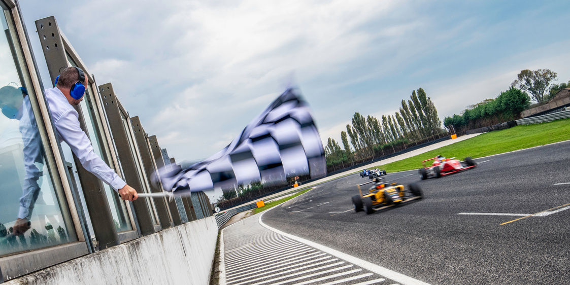 Formula race cars speeding towards the finish line